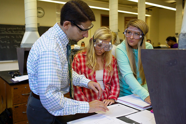 Photo of a professor with students in a science lab.
