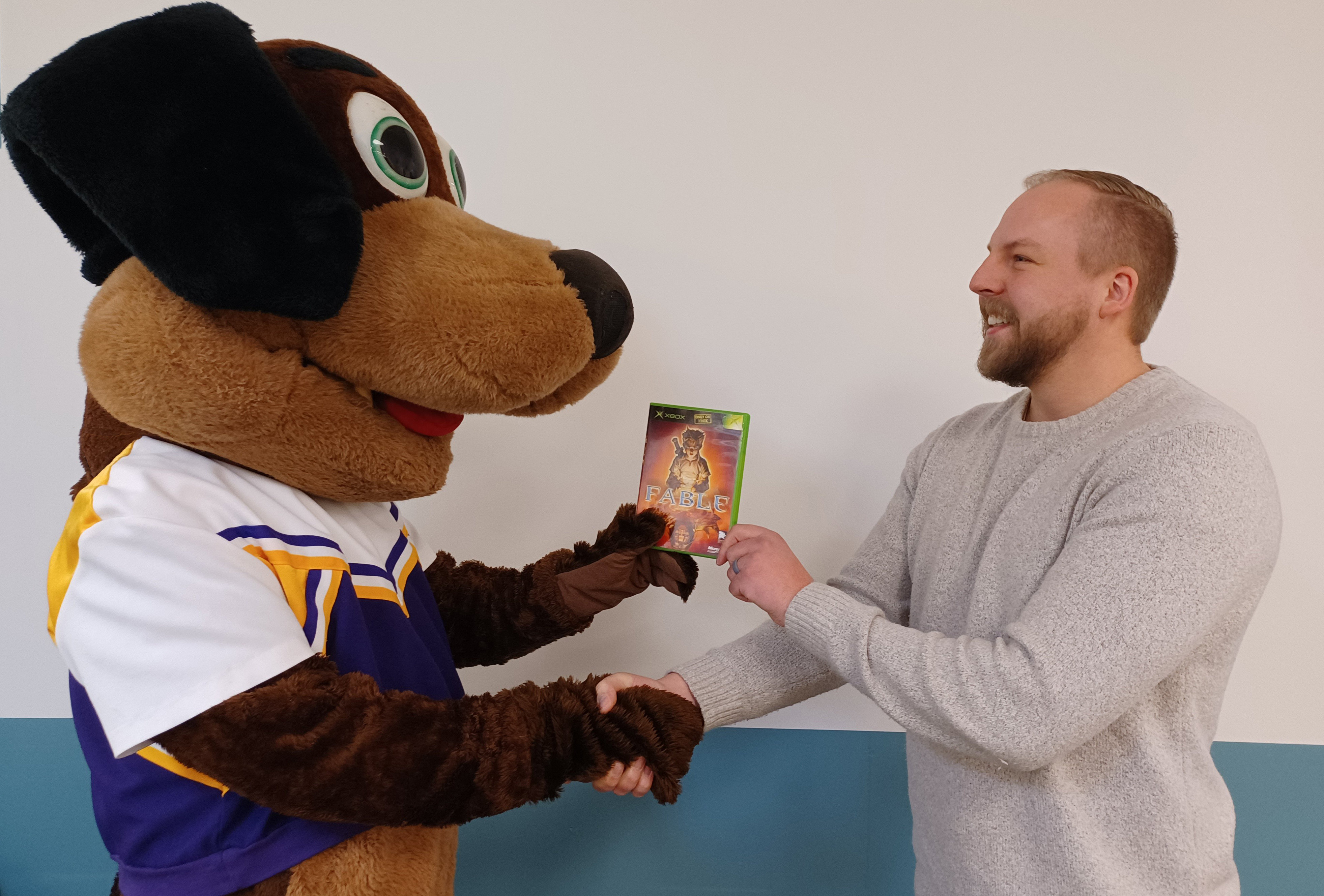 Stevie Pointer donating Xbox Fable to Archivist Kyle Neill while shaking hands