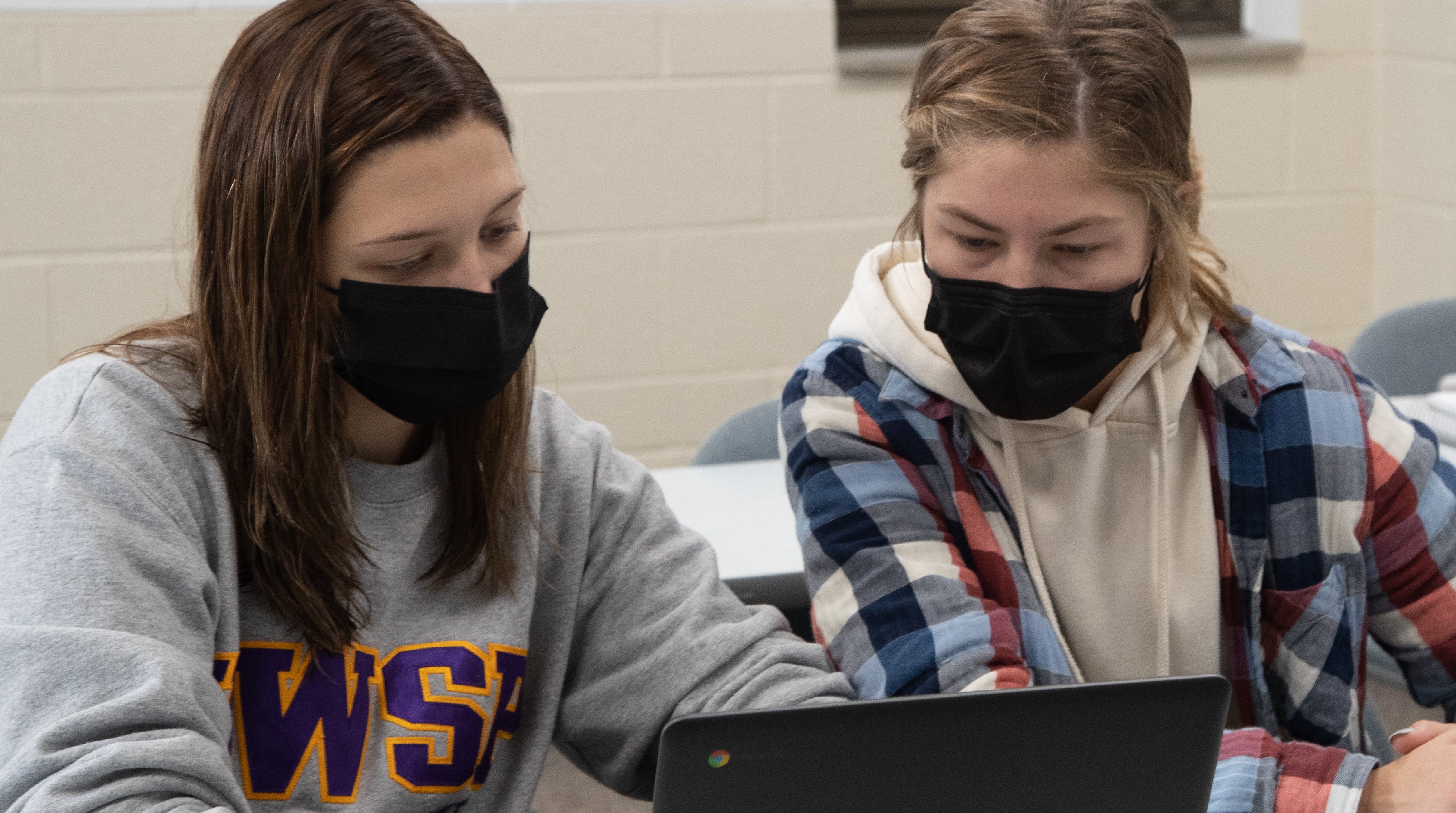Two UWSP students working together in front of a Chromebook