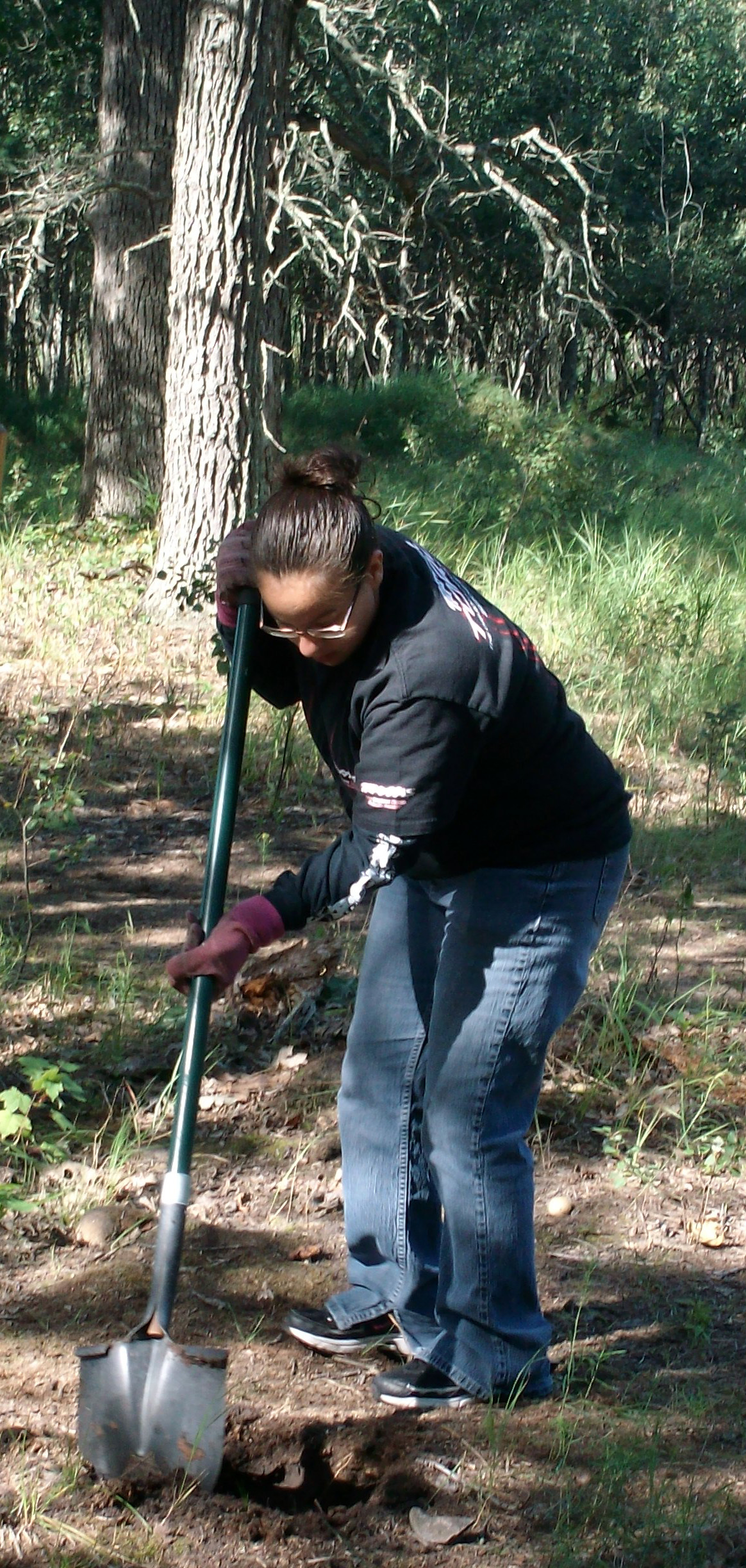 Teenage Girl Planting Tree in Forest